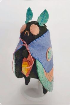 a stuffed animal wearing a blue and green outfit