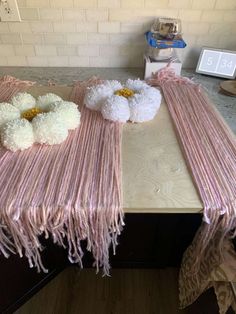 the table is covered with pink and white pom - poms