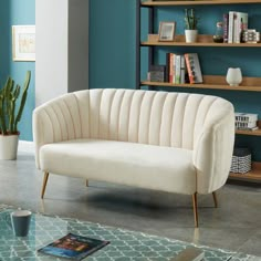 a living room with blue walls and a white couch in front of a bookshelf