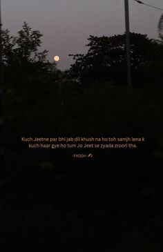 the full moon is seen in the distance behind some power lines with trees on either side