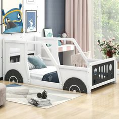 a child's bedroom with a white bed frame and black wheels on the side