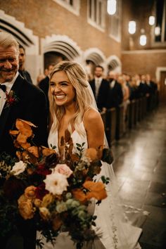 a bride and groom walking down the aisle