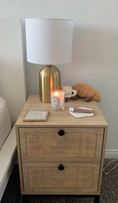 a night stand with a lamp and some items on it