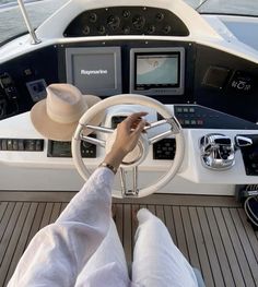 a person sitting at the wheel of a boat with their feet on the steering wheel