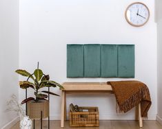 a wooden bench sitting next to a wall with a clock on it