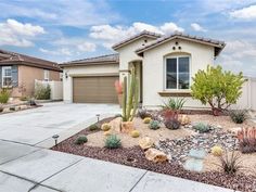 a home with cactus and cacti in the front yard