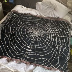 a spider web quilt on top of a bed