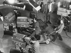 an old black and white photo of men working in a factory with equipment on the floor