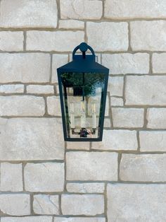 a light hanging on the side of a brick wall