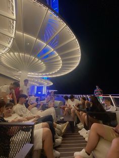 people are sitting on the deck of a cruise ship