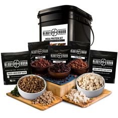 four different types of dog food in bowls on a cutting board next to a canister