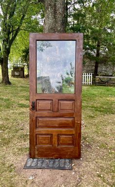 a wooden door sitting in front of a tree