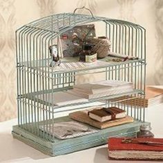 a birdcage filled with books sitting on top of a table next to a book