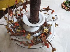 a white plate topped with a cup and saucer next to a small tree branch