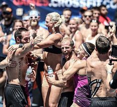 a group of people standing next to each other in front of a crowd holding water bottles