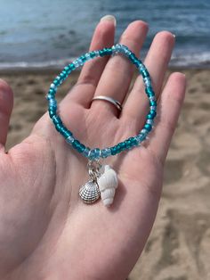 A very beach seashell bracelet set with turquoise colored beads. The set includes two turquoise beaded bracelets with seashell charms! Bracelet 1: Silver starfish charm and silver clam shell charm Bracelet 2: White seashell charm and silver seashell charm A perfect bracelet set for beach lovers! Cheap Beaded Bracelets With Heart Beads For Beach, Bracelet Beach Summer, Beachy Charm Bracelet, Beach Beads Bracelets, Sea Shells Bracelet, Shell Charm Bracelet, Turquoise Beaded Bracelets With Starfish Charm, Turquoise Shell Strand Jewelry, Turquoise Ocean-inspired Bracelet With Starfish Charm