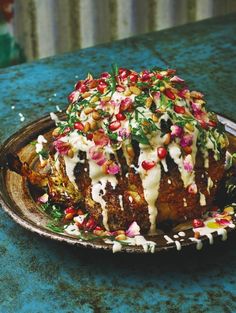 a plate filled with food on top of a blue countertop next to a knife and fork