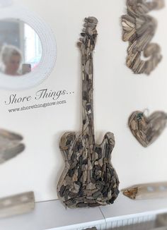 there is a guitar made out of driftwood on the wall next to a mirror