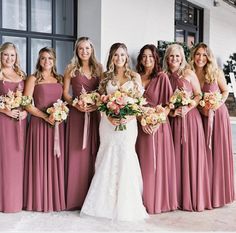 a group of women standing next to each other holding bouquets