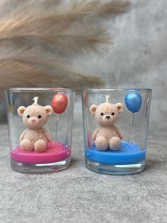 two small teddy bears sitting on top of each other in glass cups with balloons floating from them