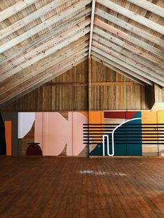 the inside of a building with wooden floors and painted wall panels on it's walls