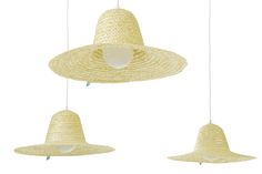 three straw hats hanging from the ceiling, one with a white hat on top and one with