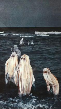 three ghost like creatures swimming in the ocean