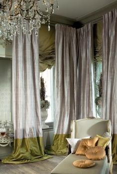 a bedroom with curtains, bed and chandelier