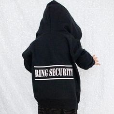 a baby wearing a black ring security hoodie with white lettering on the front and back