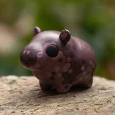 a small toy animal sitting on top of a rock