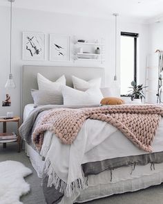 a bed with white sheets and blankets in a room filled with pictures on the wall