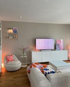 a living room filled with furniture and a flat screen tv on top of a wall