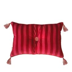 a red and white striped pillow with tassels on the front, sitting on a white background