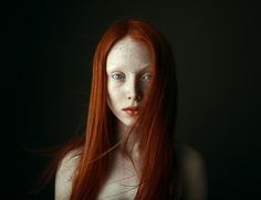 a woman with red hair and freckled skin