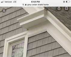 the corner of a house with a bird perched on it's window sill