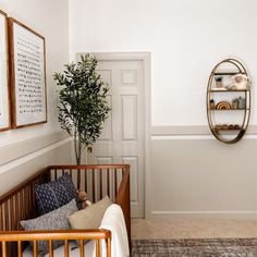 a baby's crib in the corner of a room with a potted plant