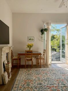 a living room filled with furniture and a flat screen tv mounted on the wall above a fireplace