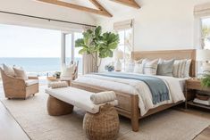 a bedroom with a large bed and lots of windows overlooking the ocean in front of it