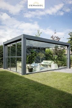 a glass house sitting on top of a lush green field