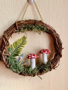 a wreath with mushrooms and ferns hanging on the wall