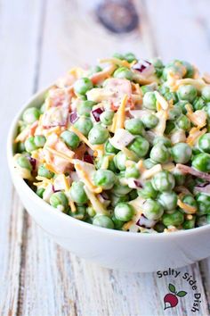 a white bowl filled with salad on top of a wooden table