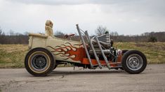 an old fashioned car with flames painted on the side