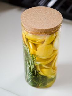 a jar filled with pickles on top of a white counter next to a stove