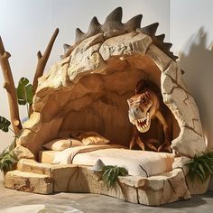 a fake dinosaur is in the middle of a bed made out of rocks and wood