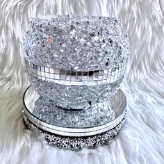 two silver dishes sitting on top of a white fur covered floor