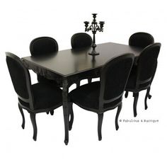 a dining table with six chairs and a small candle holder on top of the table