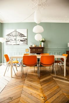 an image of a dining room setting with orange chairs