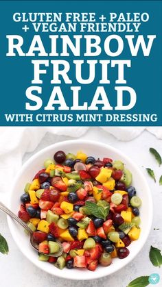 rainbow fruit salad with citrus mint dressing in a white bowl on top of a table