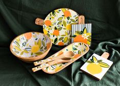 an assortment of wooden utensils and plates on a green cloth