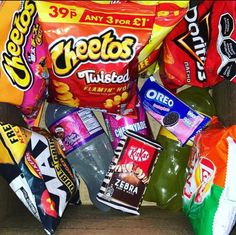 an assortment of chips and snacks sitting on top of a wooden table next to each other